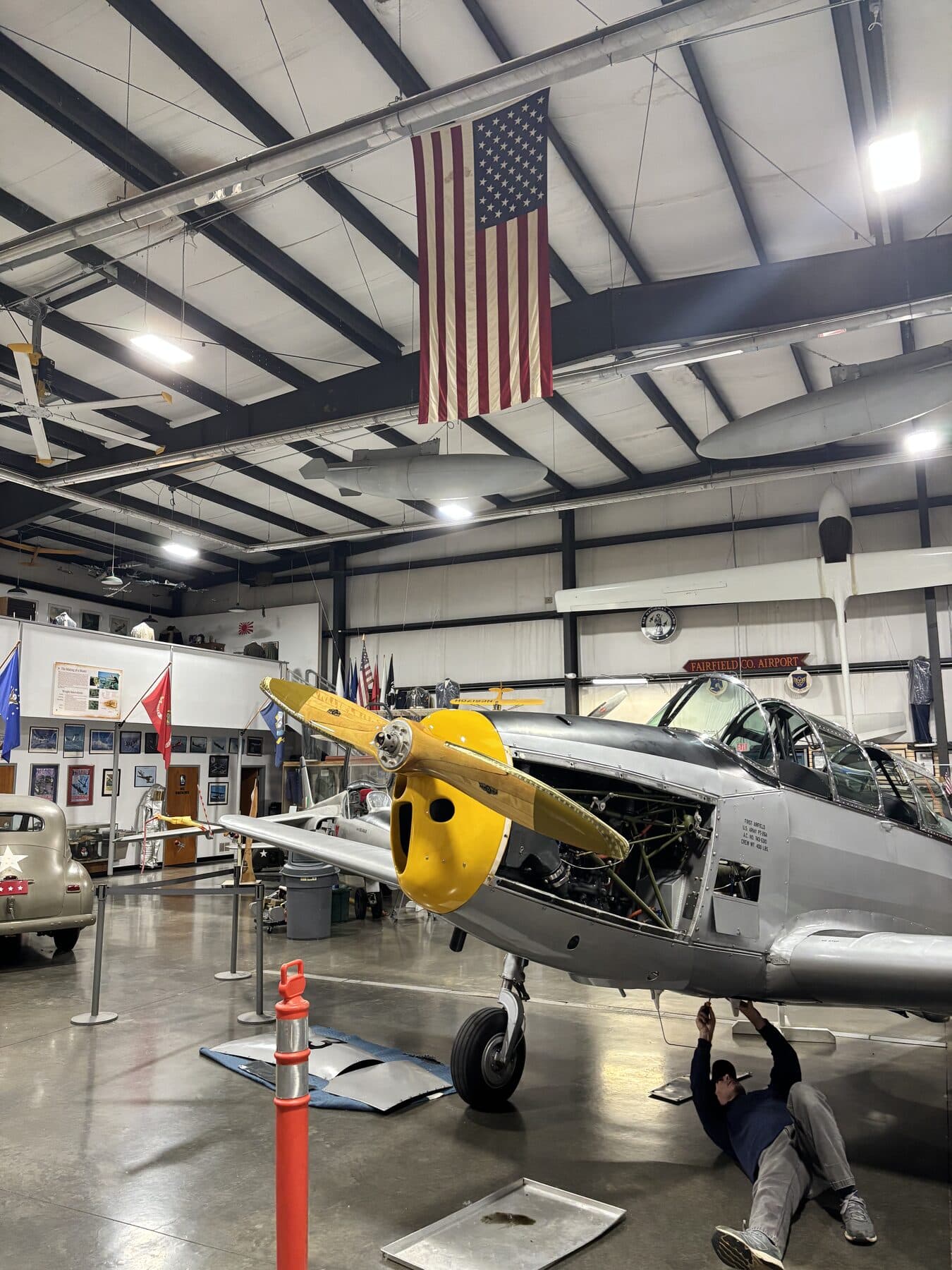The Hawaii Wing's Fairchild PT-26 Cornell, N49071, beneath the American flag in the hangar